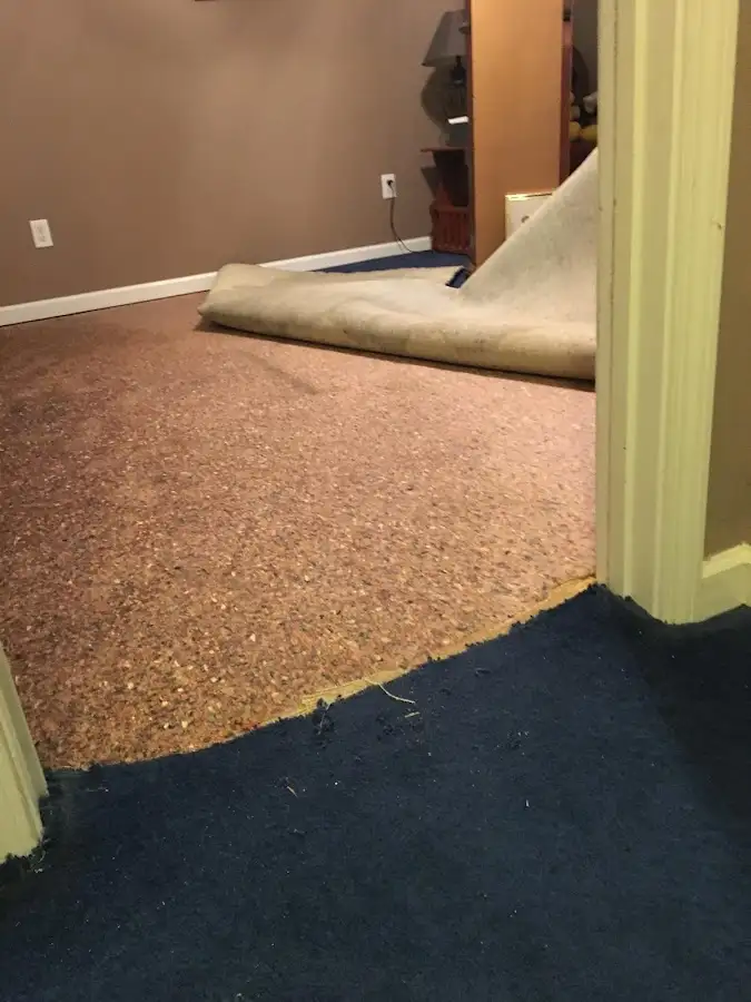 Carpet pad removal revealing water damage during Water Mitigation Services in Central City